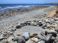 Sunbathers along some of the rocky beaches of the southern coast create small craters that serve as a wind barrier.