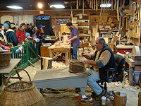 Artisans work with traditional tools and demonstrate techniques used by the colonists and Native Americans .